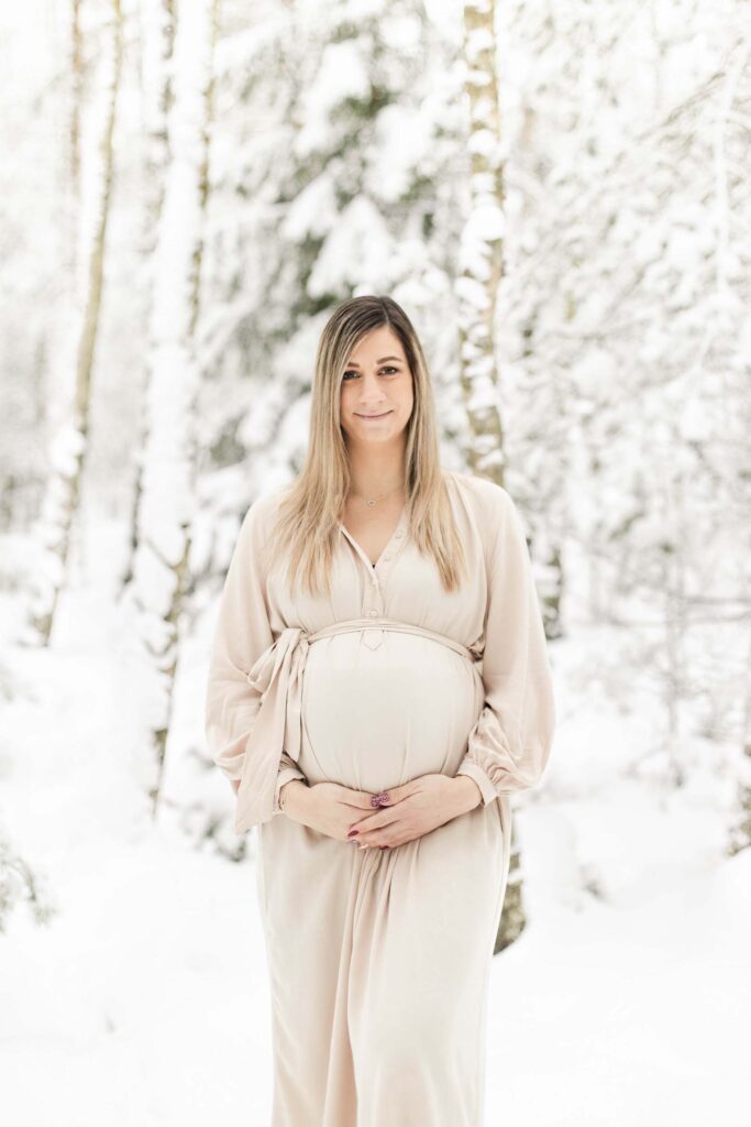 Vinter gravidfotografering i skogen med snö på träden i Göteborg